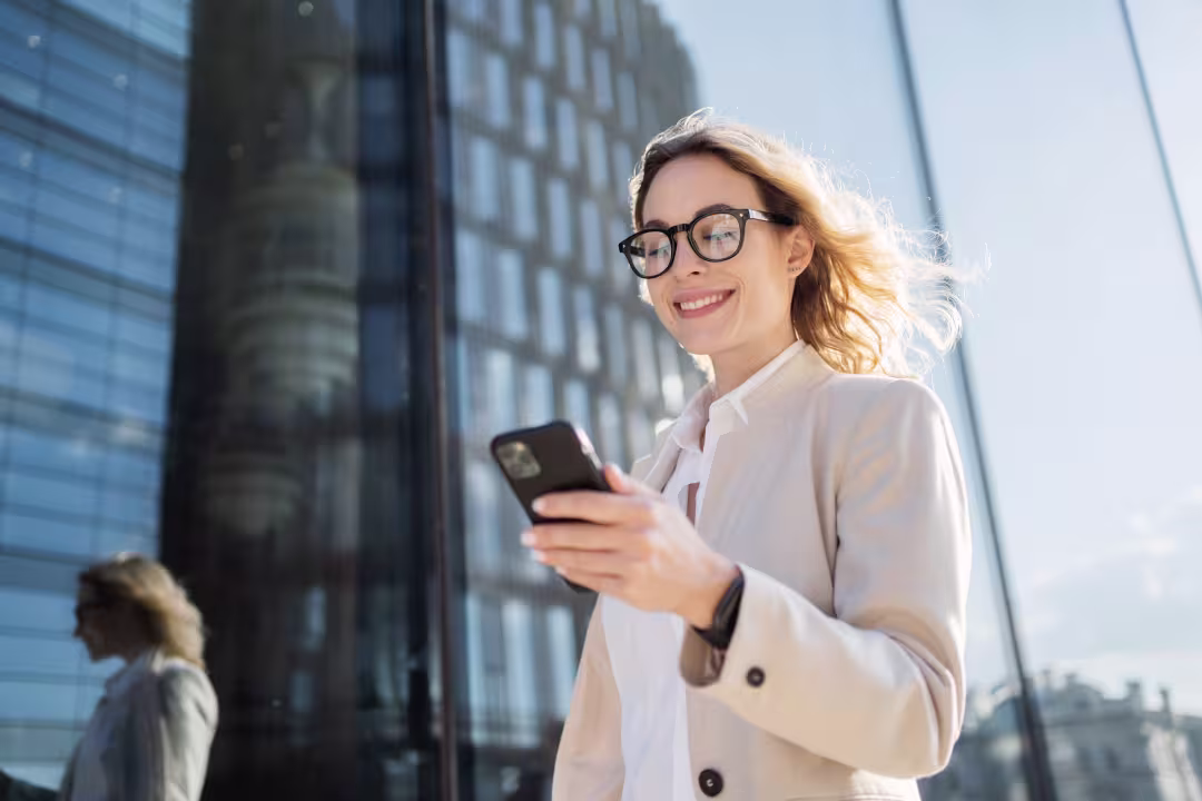 Frau schaut lächelnd auf Handy